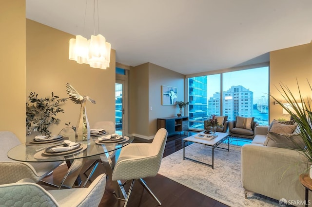 living area featuring wood finished floors, floor to ceiling windows, a chandelier, plenty of natural light, and a view of city