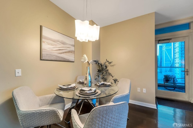 dining room featuring wood finished floors, baseboards, and a chandelier