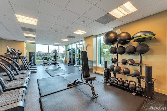workout area with baseboards and a drop ceiling