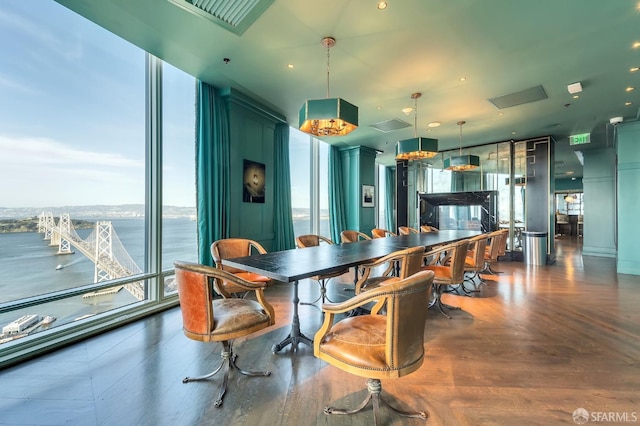 dining space featuring a water view and wood finished floors