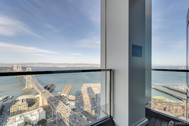 balcony featuring a water view and a city view