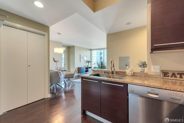 kitchen featuring stainless steel dishwasher, a sink, a peninsula, dark wood finished floors, and light stone countertops