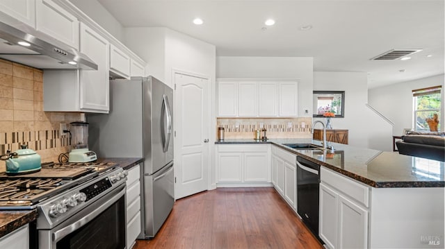kitchen featuring a sink, gas range, a peninsula, range hood, and visible vents