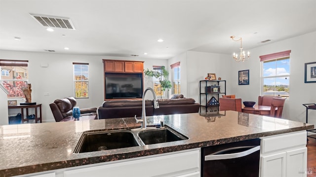 kitchen with dishwasher, open floor plan, a sink, and visible vents