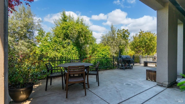 view of patio / terrace featuring a grill, fence, and outdoor dining space