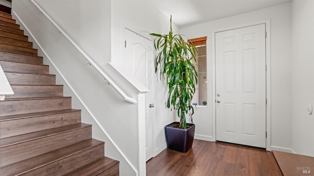 entrance foyer with stairway, baseboards, and wood finished floors