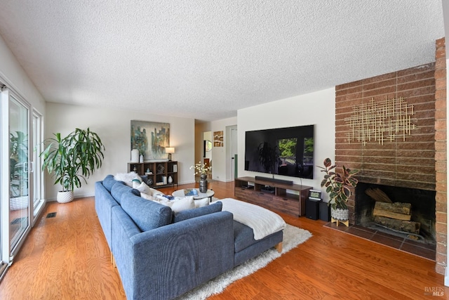 15 Manor View Dr, Fairfax, CA 94930 - living room with wood finished floors, a textured ceiling, visible vents, and a fireplace