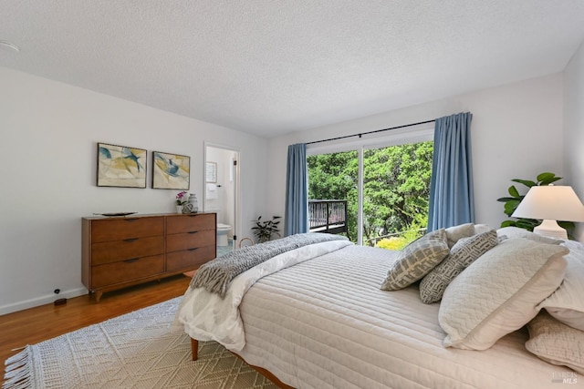 15 Manor View Dr, Fairfax, CA 94930 - bedroom featuring wood finished floors, a textured ceiling, and connected bathroom