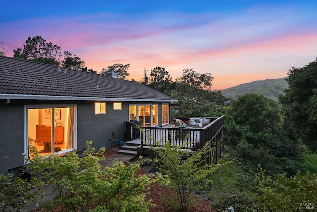 15 Manor View Dr, Fairfax, CA 94930 - back of property at dusk with stucco siding, a deck with mountain view, a chimney, and a tile roof