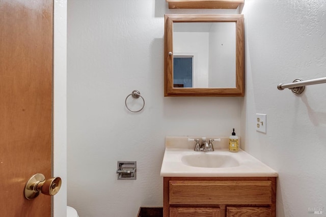 half bathroom with toilet and vanity