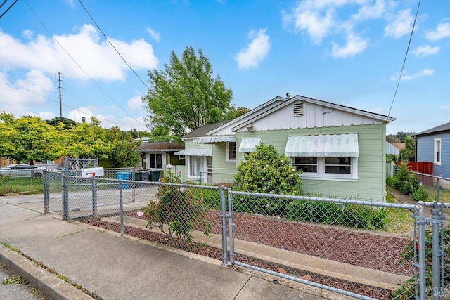 bungalow-style house featuring board and batten siding, fence private yard, and a gate