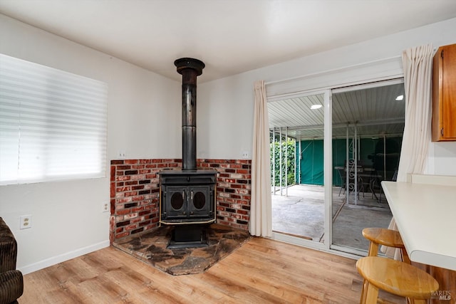 room details with baseboards, a wood stove, and wood finished floors