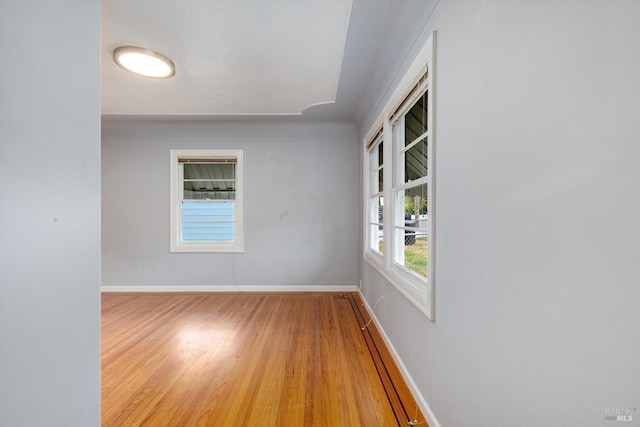 unfurnished room featuring baseboards and wood finished floors
