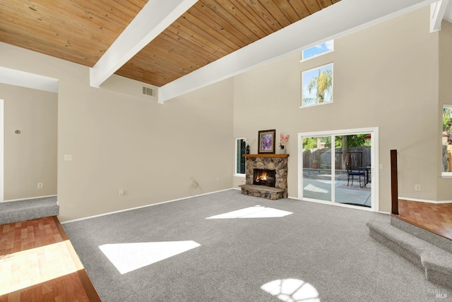 unfurnished living room featuring wood ceiling, carpet, visible vents, and a fireplace