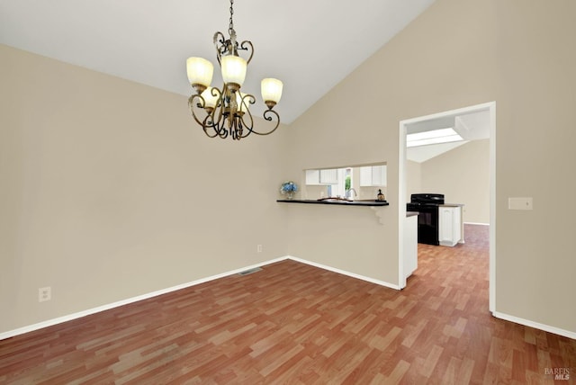 empty room with a chandelier, light wood-style flooring, visible vents, and baseboards