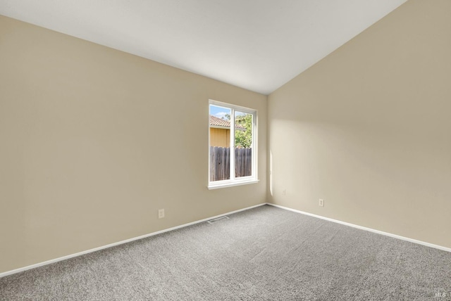 spare room with baseboards, vaulted ceiling, visible vents, and carpet floors