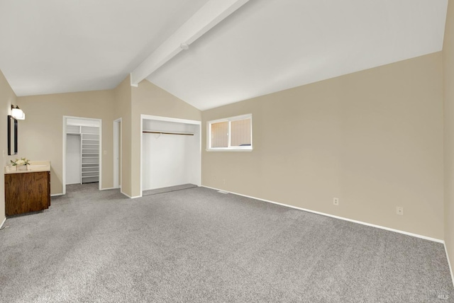 unfurnished bedroom featuring carpet floors, baseboards, and lofted ceiling with beams