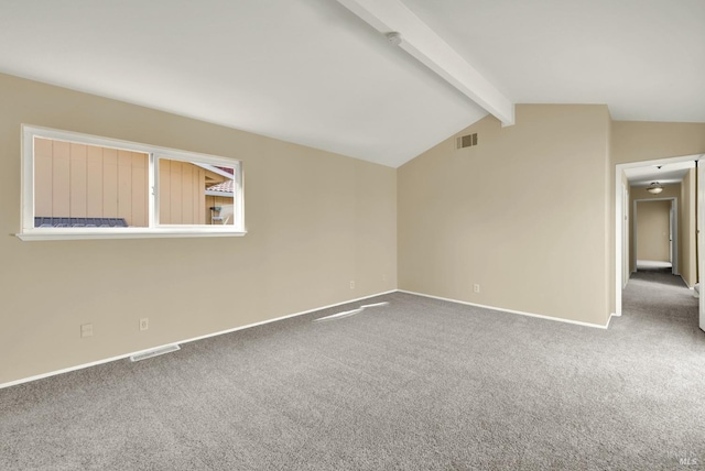 carpeted spare room with visible vents, vaulted ceiling with beams, and baseboards