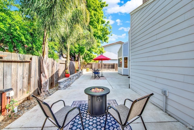 view of patio featuring a fire pit, outdoor dining area, and a fenced backyard