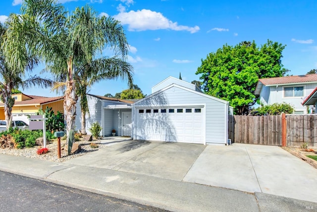 single story home with fence, driveway, and a garage