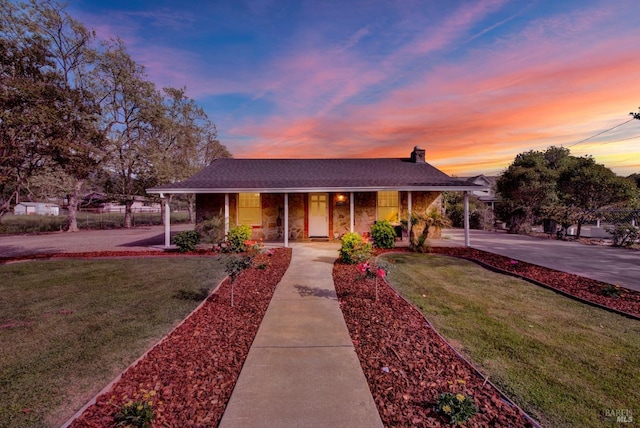 view of front of home with a chimney, fence, a porch, and a yard