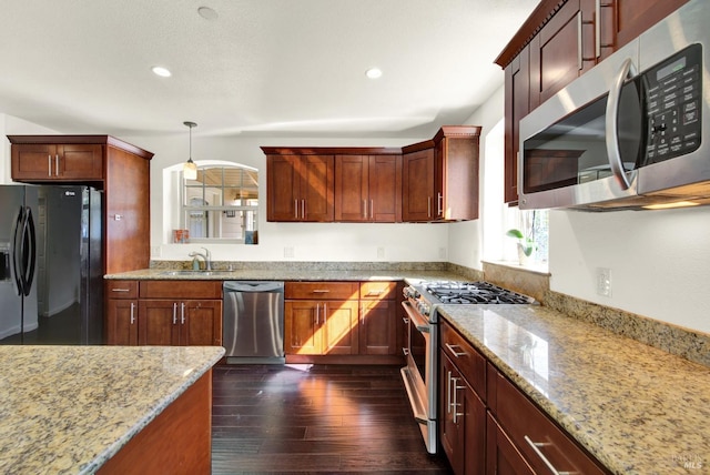kitchen featuring stainless steel appliances, a sink, recessed lighting, light stone countertops, and dark wood-type flooring