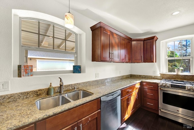 kitchen featuring stainless steel appliances, a sink, dark wood-type flooring, and light stone counters