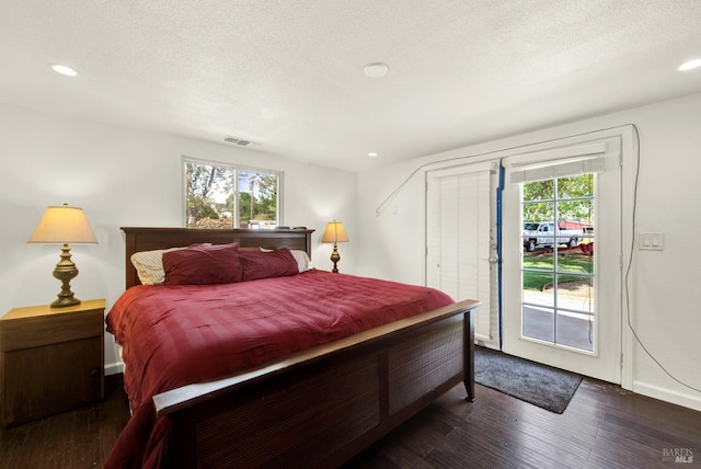 bedroom with recessed lighting, wood finished floors, access to exterior, and visible vents
