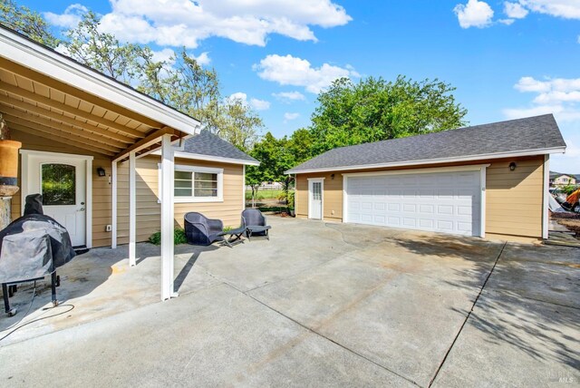 exterior space with a detached garage and an outbuilding