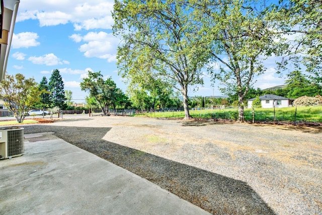 view of yard with central air condition unit and fence