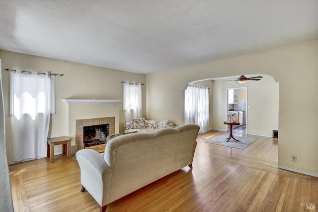 1467 Ohio St, Vallejo, CA 94590 - living room featuring arched walkways, a brick fireplace, light wood-type flooring, and ceiling fan