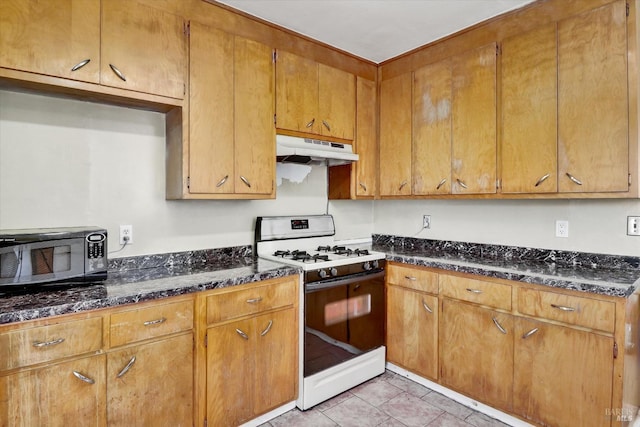 1467 Ohio St, Vallejo, CA 94590 - kitchen with gas range, under cabinet range hood, black microwave, dark stone countertops, and light tile patterned flooring
