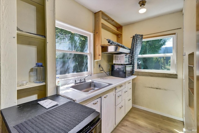 1467 Ohio St, Vallejo, CA 94590 - kitchen with black microwave, open shelves, a sink, white cabinets, and light wood finished floors