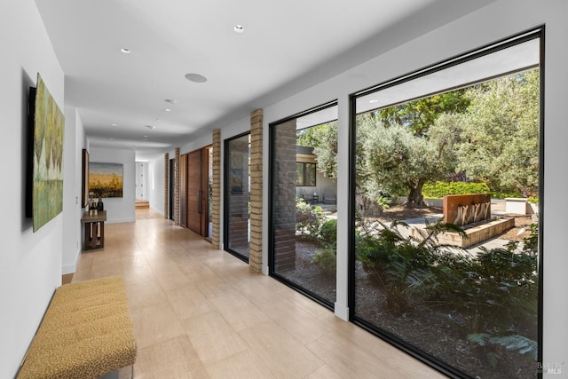 hall with recessed lighting and baseboards