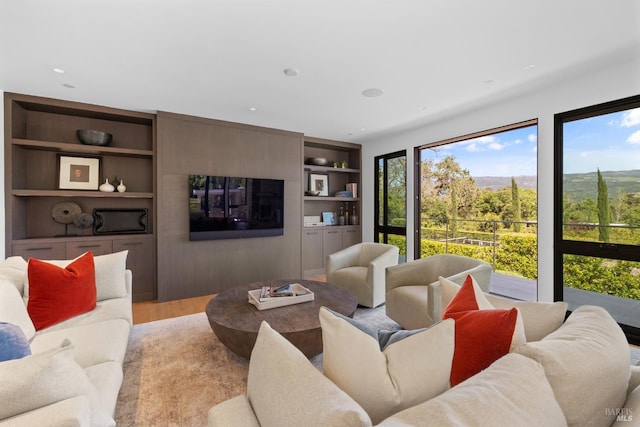 living area featuring light wood-type flooring, built in features, and recessed lighting