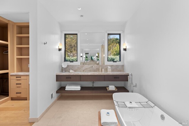 bathroom featuring baseboards, visible vents, vanity, and built in shelves