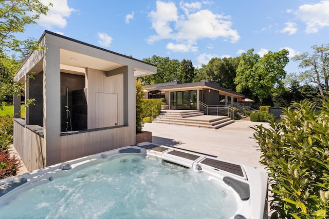 exterior space with a wooden deck and an outdoor hot tub