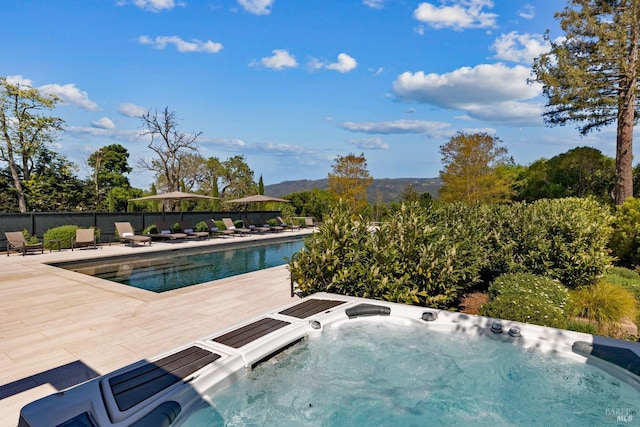 view of pool featuring fence, a hot tub, a patio area, and a fenced in pool