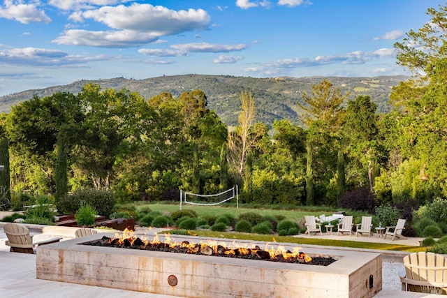 surrounding community featuring an outdoor fire pit and a mountain view