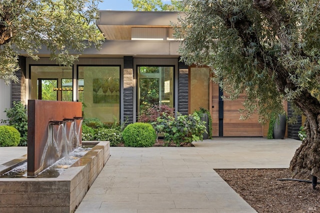 view of exterior entry featuring a garage, stucco siding, and concrete driveway