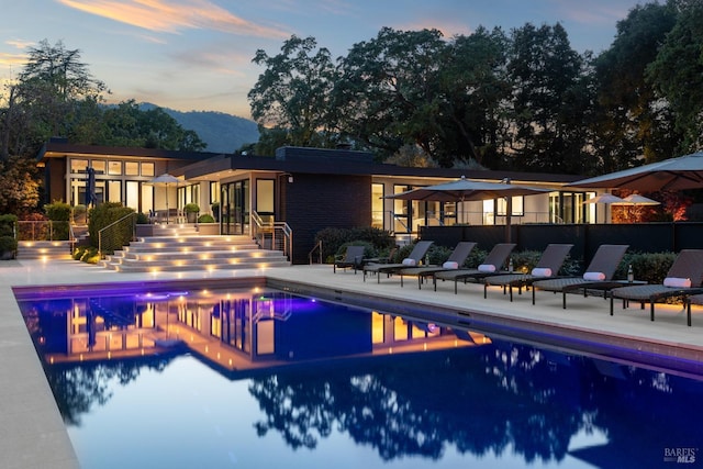 community pool with a patio and a mountain view