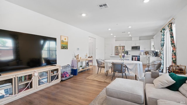 living room featuring wood finished floors, visible vents, and recessed lighting