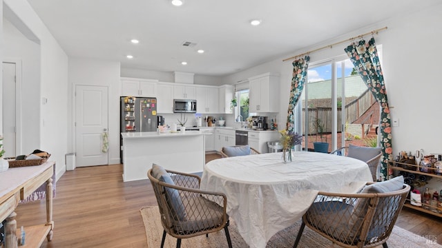 dining area with light wood-style floors, visible vents, and recessed lighting