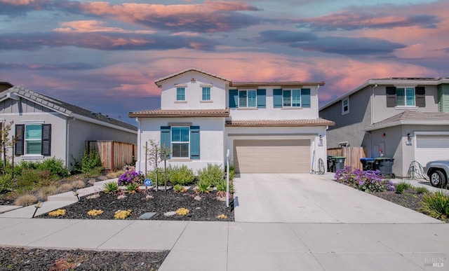 traditional home featuring fence, stucco siding, an attached garage, a tile roof, and driveway
