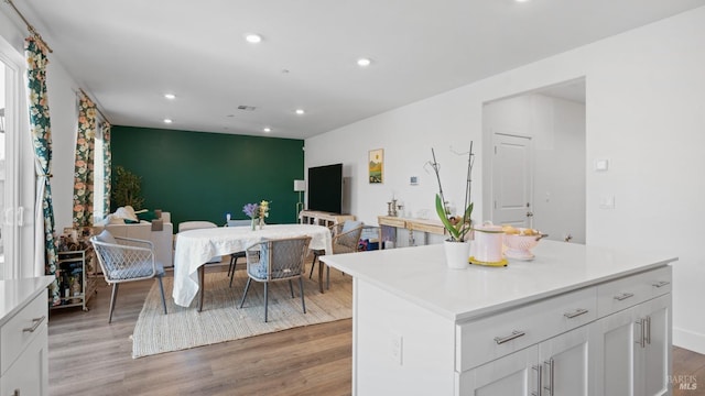 kitchen with recessed lighting, light wood-style floors, an accent wall, and open floor plan