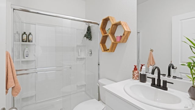 bathroom with toilet, vanity, and a stall shower
