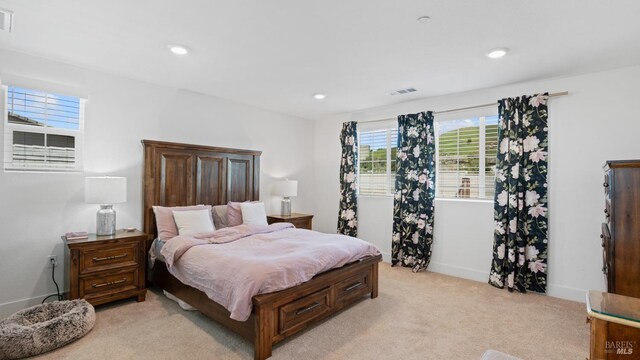 bedroom featuring light carpet, visible vents, and recessed lighting