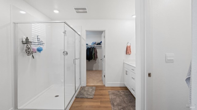 full bathroom with wood finished floors, visible vents, vanity, and a stall shower