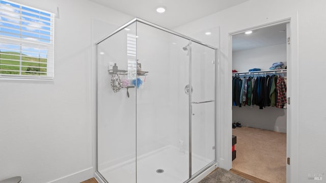 bathroom with a spacious closet, recessed lighting, and a stall shower