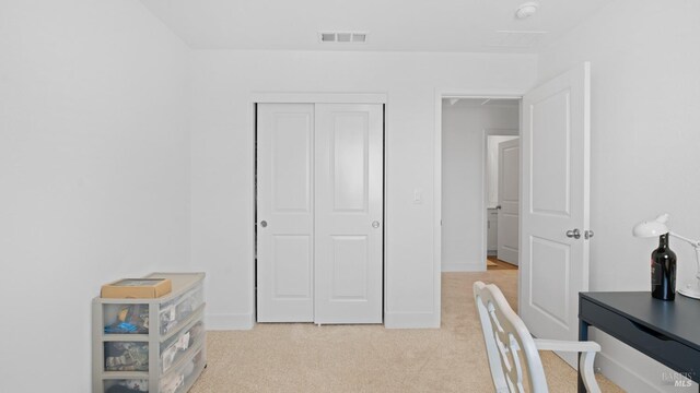 home office with visible vents, baseboards, and light carpet